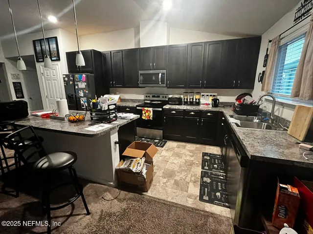 a kitchen with stainless steel appliances kitchen island granite countertop a sink stove and cabinets
