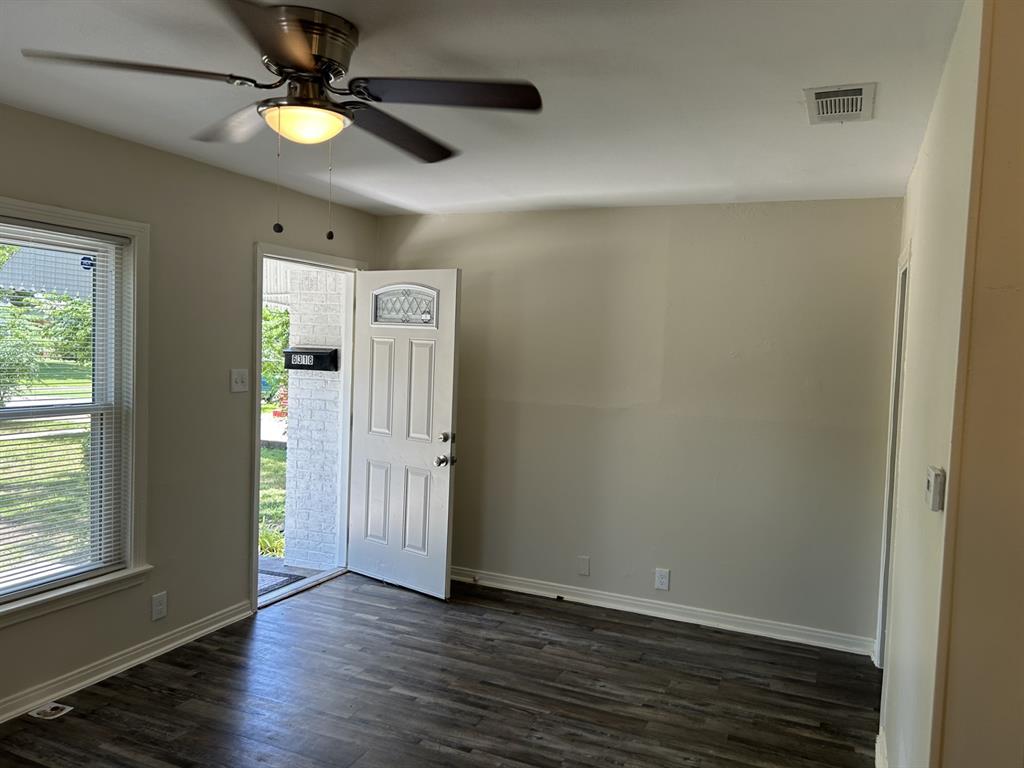 6318 Belgrade Avenue Dallas, TX 75227 - Photo 5 of 23 an empty room with wooden floor fan and windows