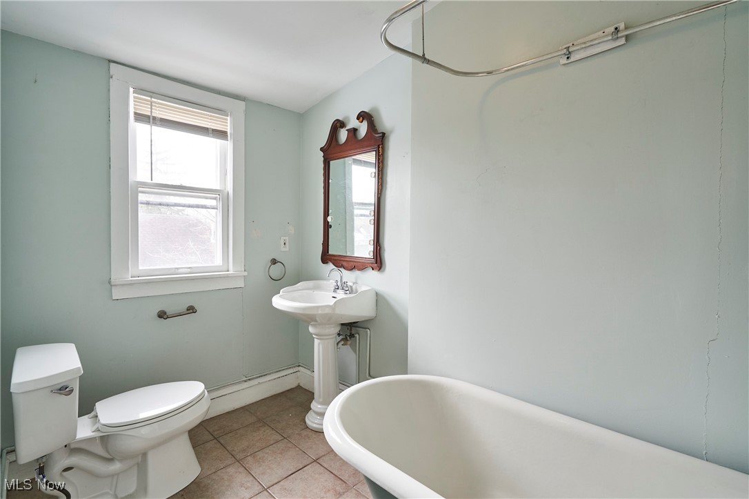 2152 Middlefield Road Cleveland, OH 44106 - Photo 23 of 50 Bathroom with a washtub, tile patterned flooring, toilet, and baseboard heating