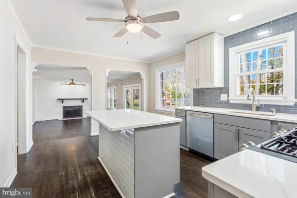a kitchen with a sink dishwasher a stove and a refrigerator with wooden floor