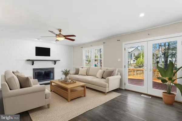 an empty room with wooden floor fireplace and windows