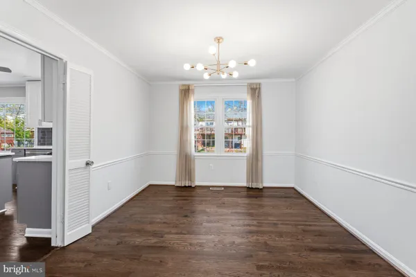 a dining room with furniture a chandelier and wooden floor