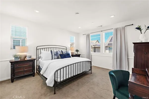 a bedroom with a bed window and a chair