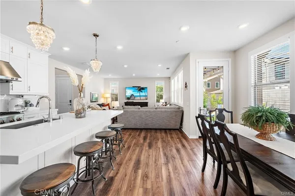 a living room with furniture a refrigerator a dining table and chairs
