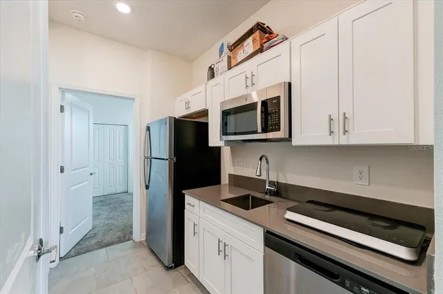a kitchen with stainless steel appliances a refrigerator sink and microwave