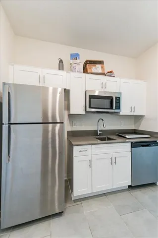 a kitchen with stainless steel appliances granite countertop a sink and a refrigerator