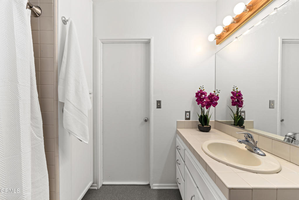 917 West W Victoria Street Santa Barbara, CA 93101 - Photo 17 of 28 a bathroom with a granite countertop sink and a mirror