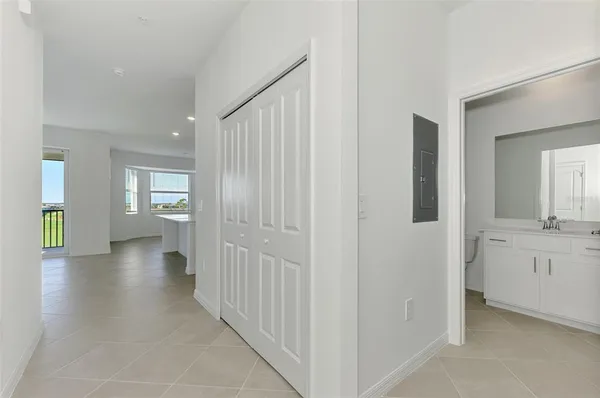 a view of a hallway with wooden floor windows and a kitchen