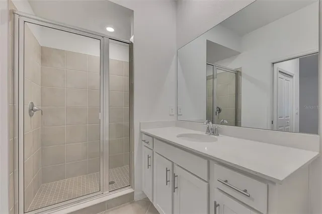 a bathroom with a shower sink and mirror