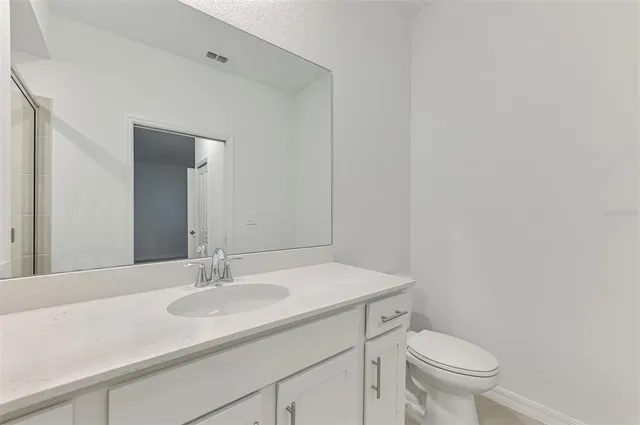 a bathroom with a sink toilet and a mirror