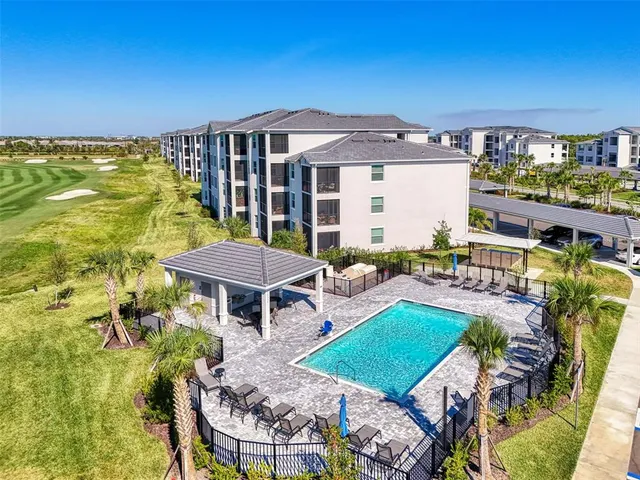 a view of a house with pool and chairs