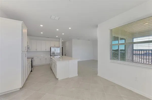 a view of a kitchen with furniture and refrigerator