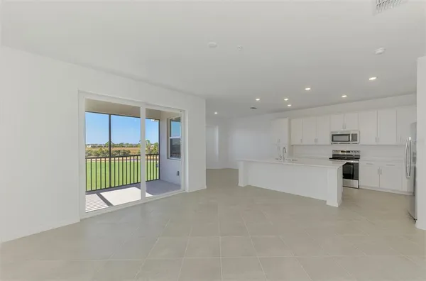 a view of kitchen with kitchen island and stainless steel appliances