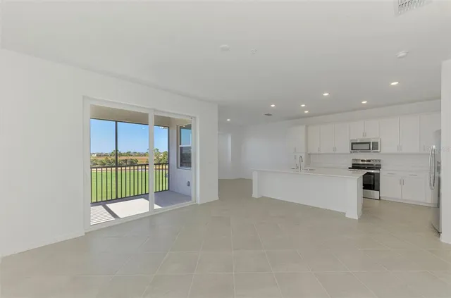 a view of kitchen with kitchen island and stainless steel appliances