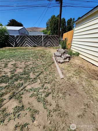 a view of a backyard with chairs and potted plants