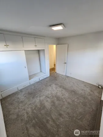 an empty room with closet and windows