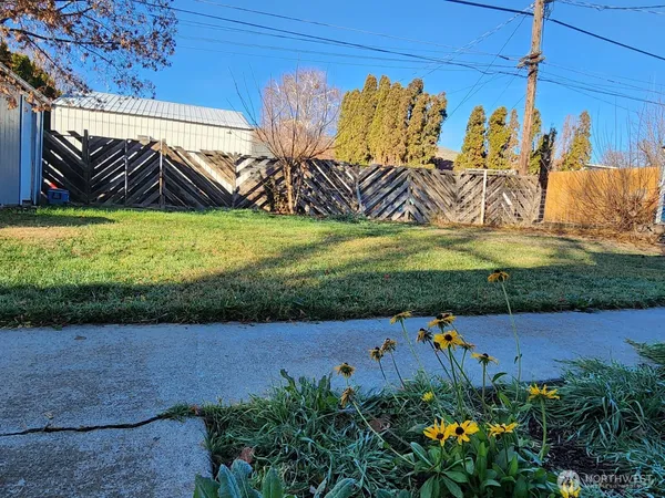 a view of a backyard with table and chairs with wooden fence and plants