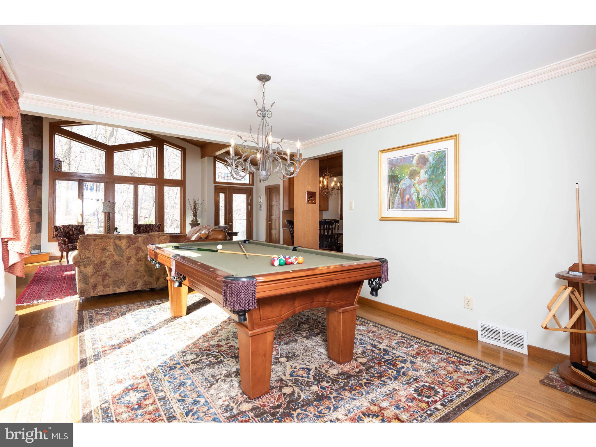 535 Upper Weadley Road Wayne, PA 19087 - Photo 21 of 44 a dining room with wooden floor a chandelier a wooden table and chairs