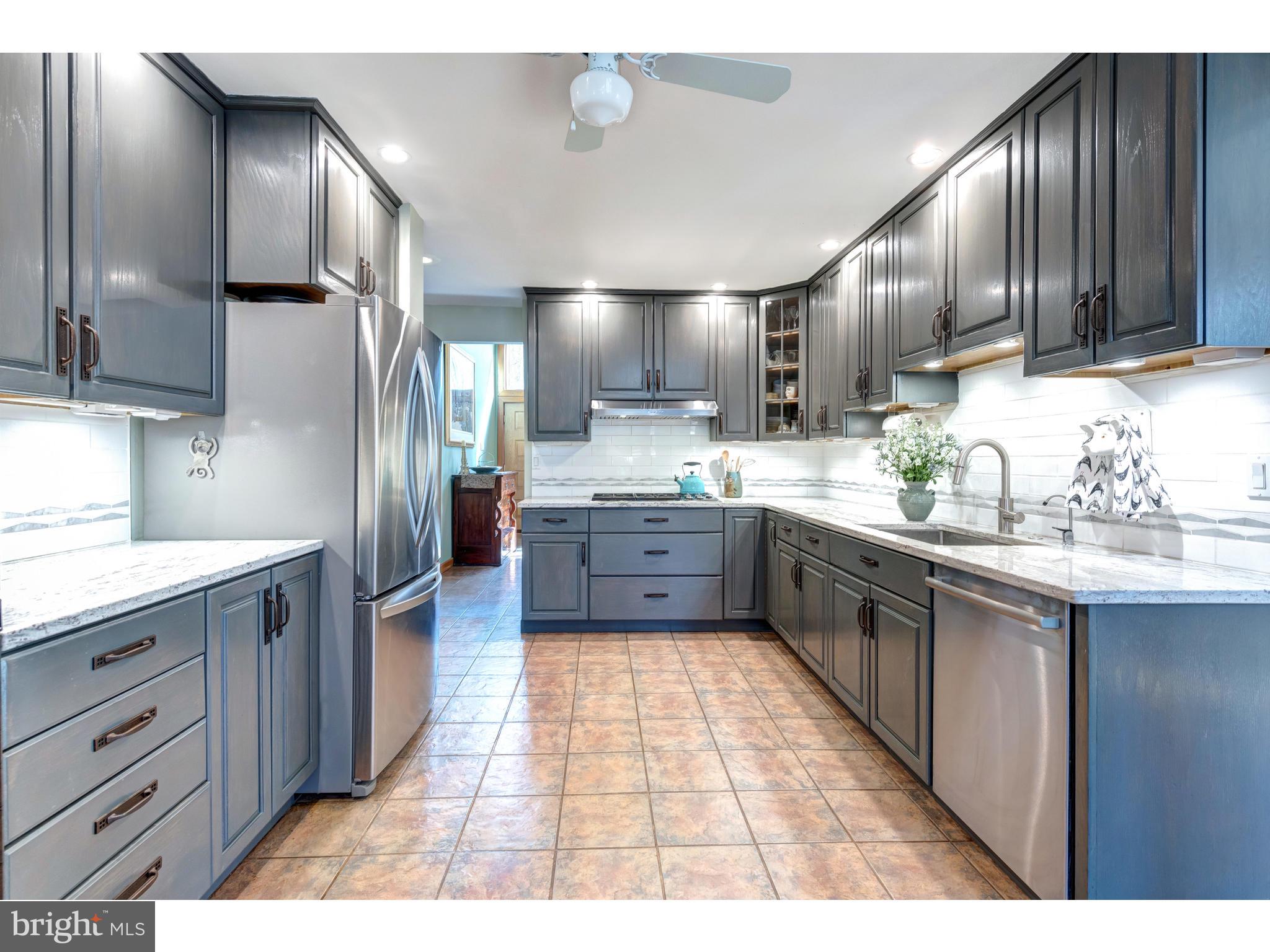 535 Upper Weadley Road Wayne, PA 19087 - Photo 24 of 44 a kitchen with stainless steel appliances kitchen island granite countertop a sink refrigerator and cabinets