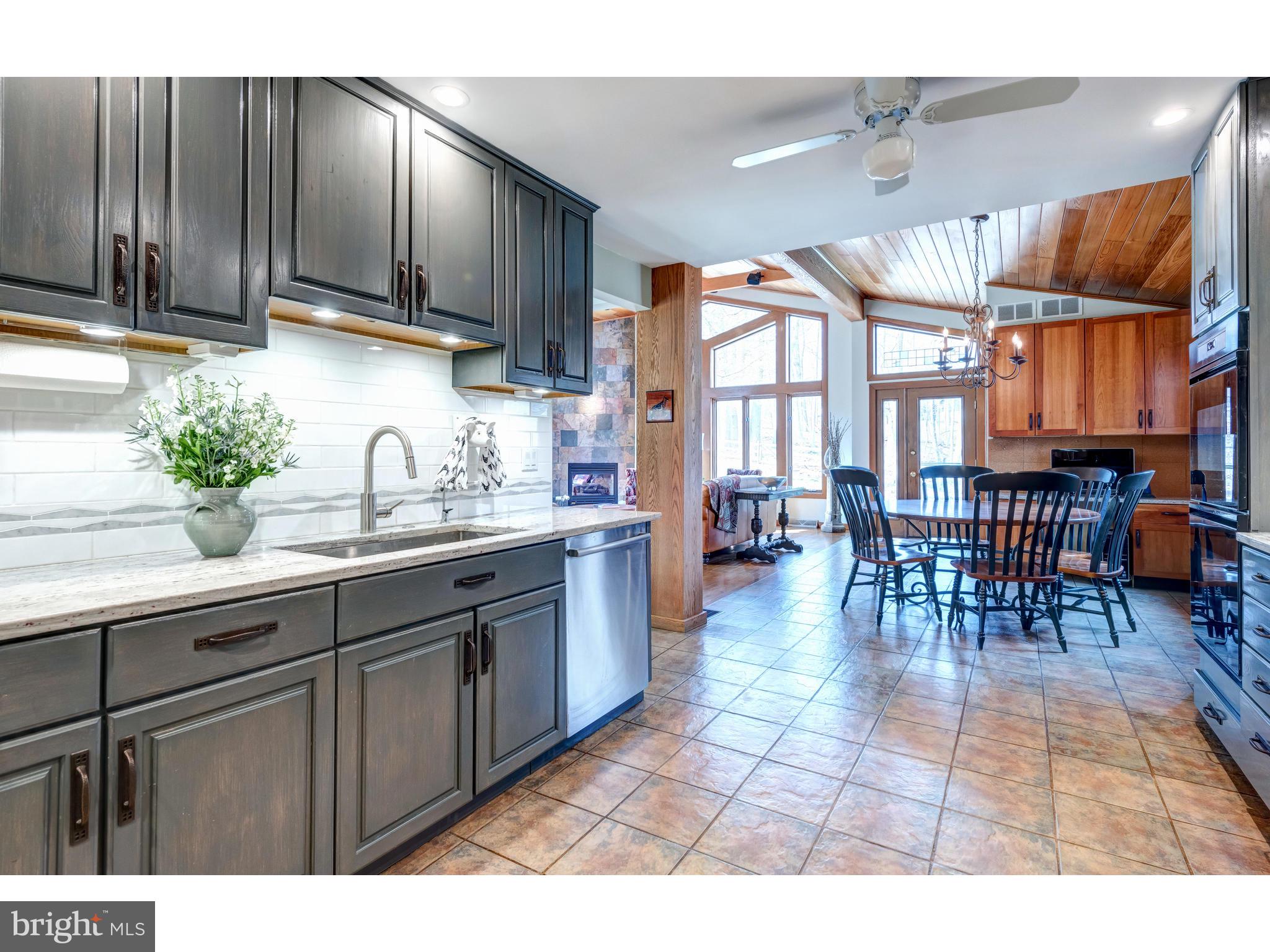 535 Upper Weadley Road Wayne, PA 19087 - Photo 26 of 44 a open kitchen with granite countertop a stove a sink a dining table and chairs