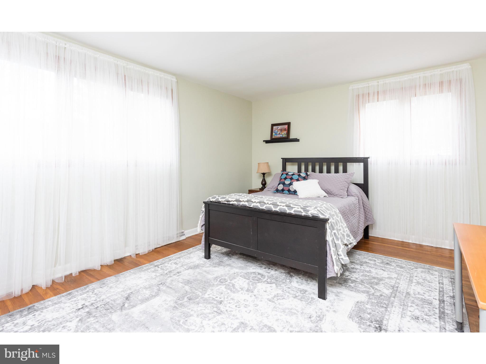 535 Upper Weadley Road Wayne, PA 19087 - Photo 31 of 44 a bed sitting in a bedroom next to a window with a wooden floor