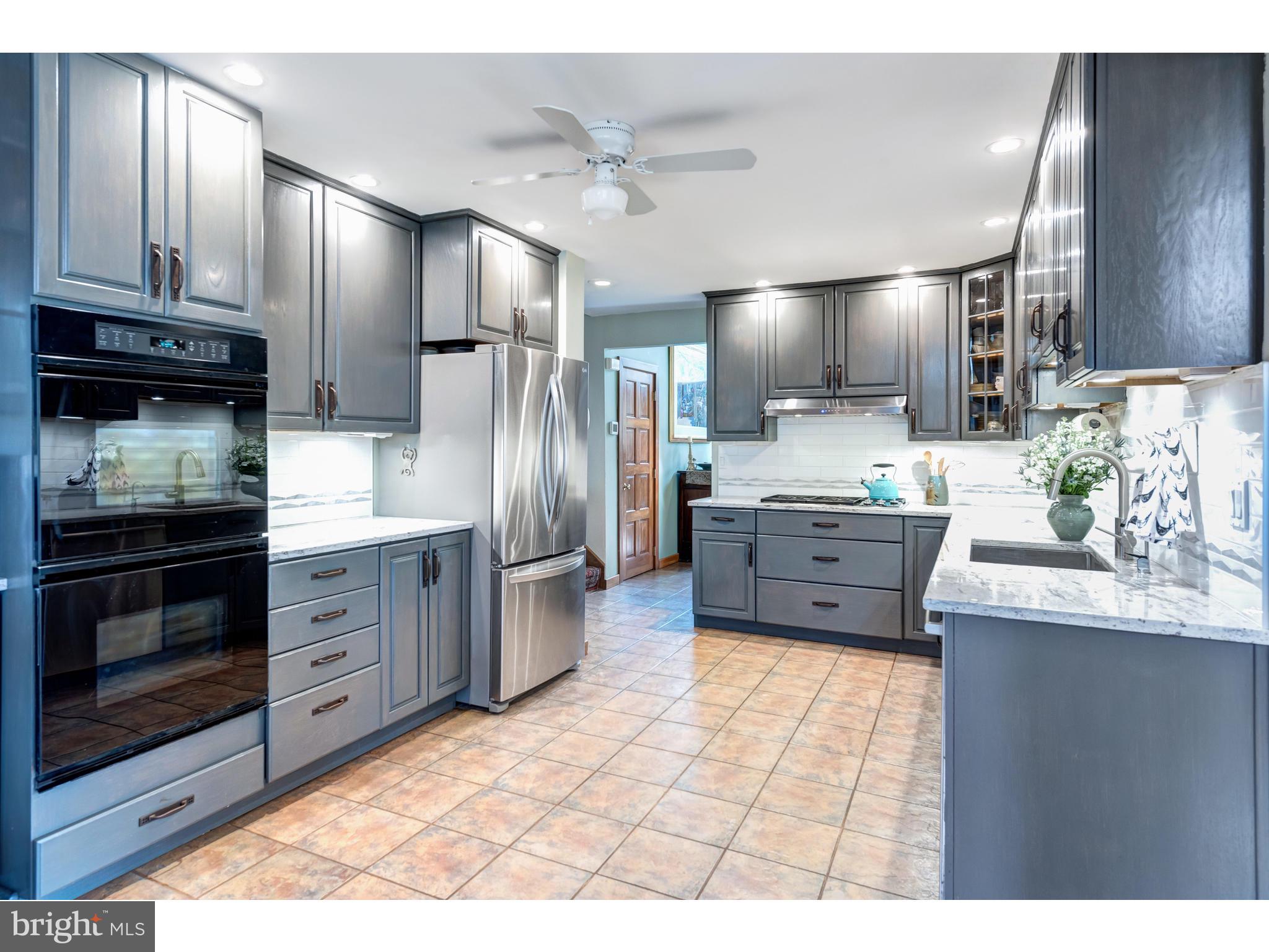 535 Upper Weadley Road Wayne, PA 19087 - Photo 6 of 44 a kitchen with stainless steel appliances kitchen island granite countertop a stove refrigerator and cabinets