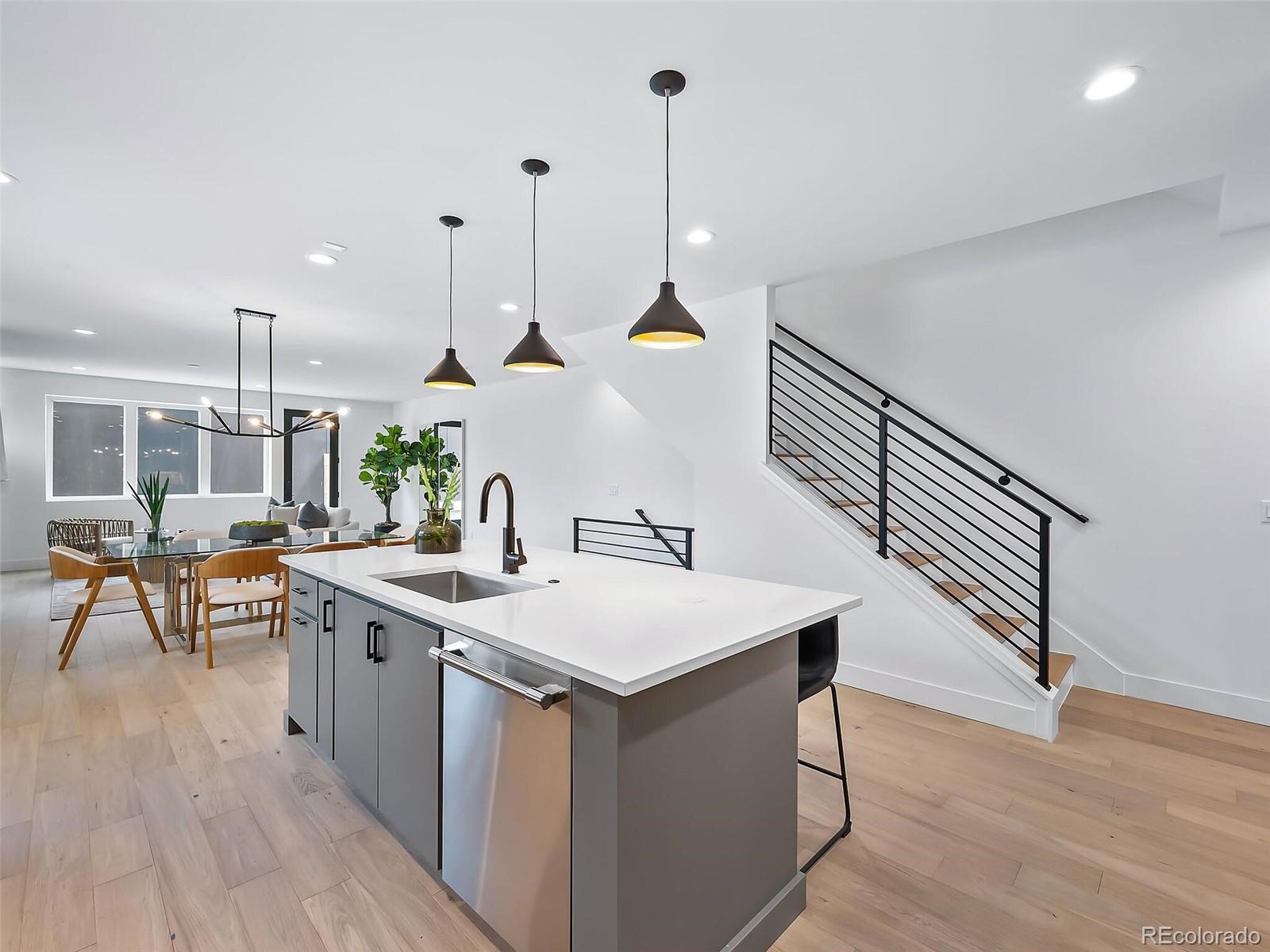 588 Adams Street Denver, CO 80206 - Photo 11 of 41 a room with stainless steel appliances kitchen island a white cabinets and wooden floor