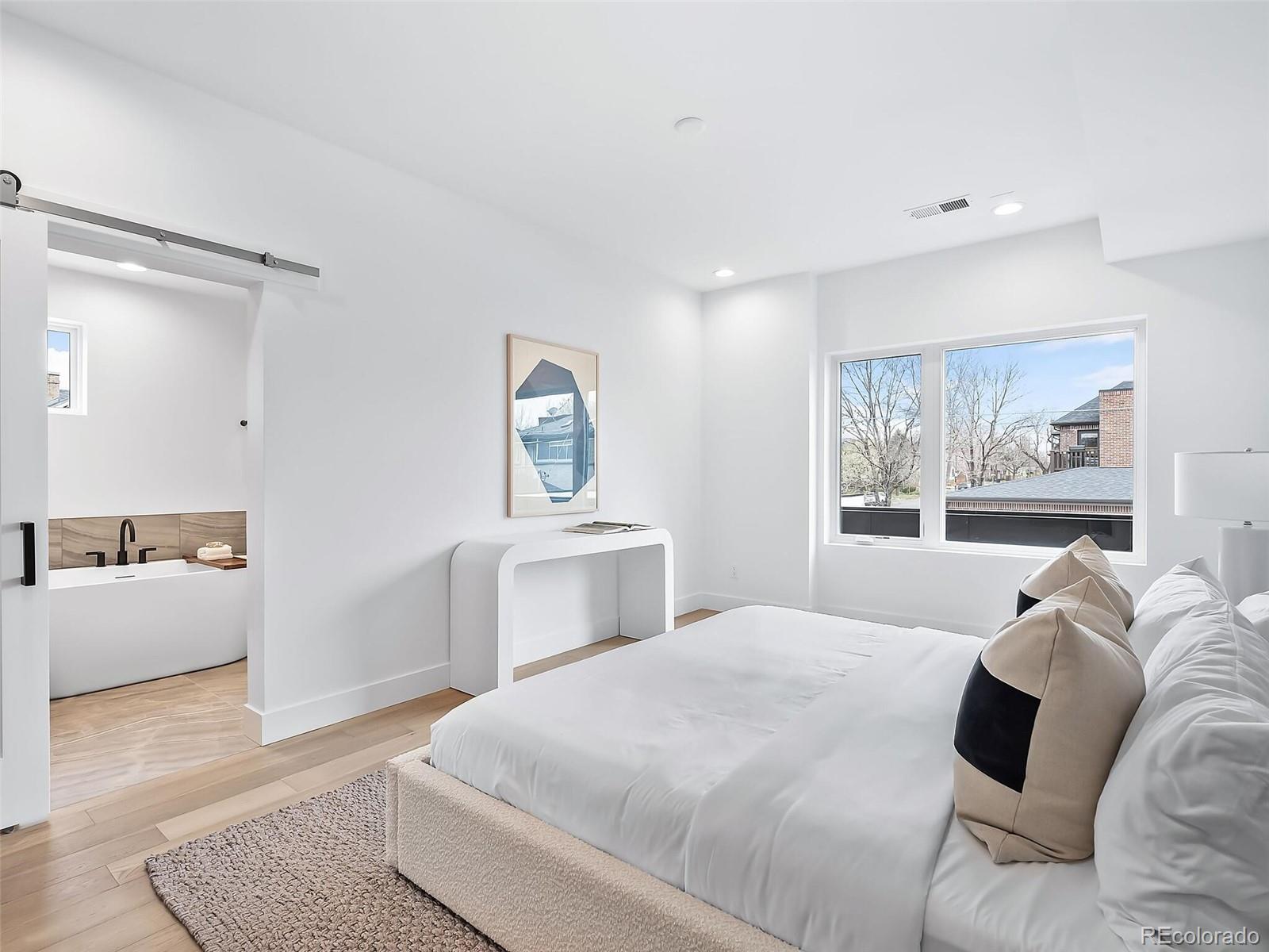 588 Adams Street Denver, CO 80206 - Photo 13 of 41 a bedroom with a large bed and a couch