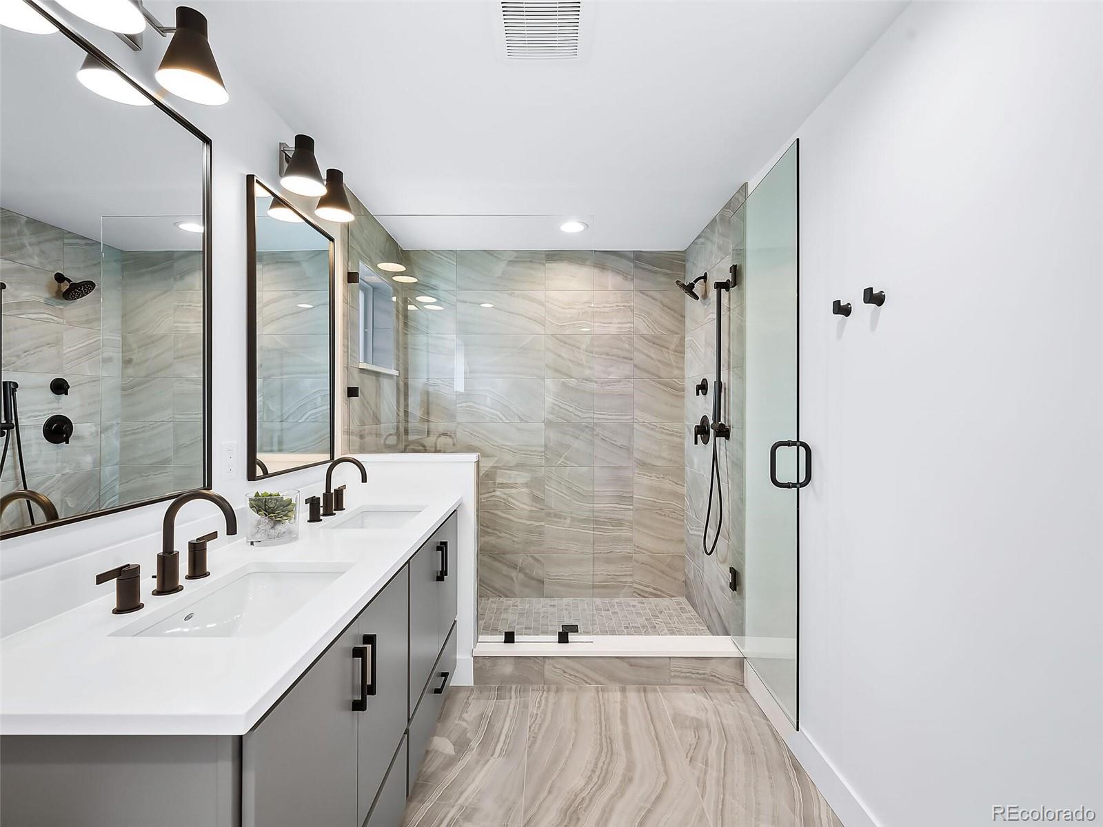 588 Adams Street Denver, CO 80206 - Photo 14 of 41 a bathroom with a double vanity sink a toilet and shower