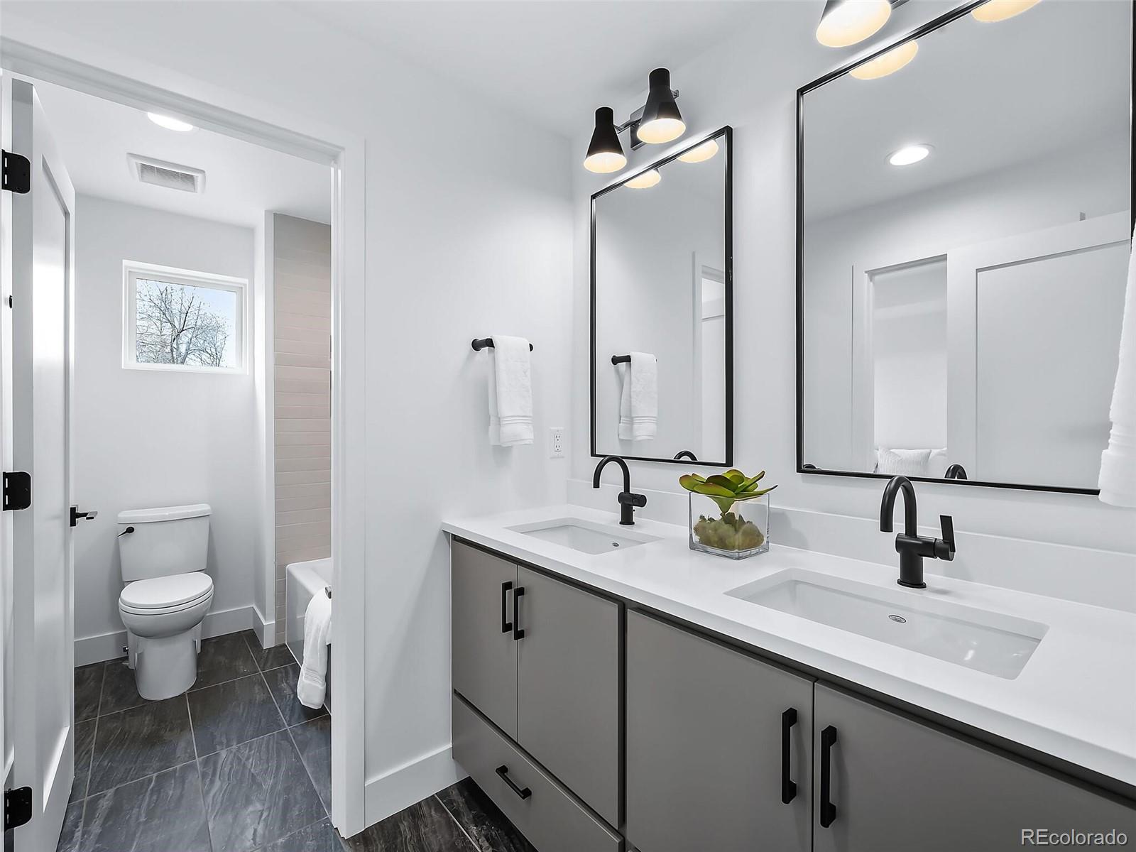 588 Adams Street Denver, CO 80206 - Photo 19 of 41 a bathroom with a sink a toilet and a mirror
