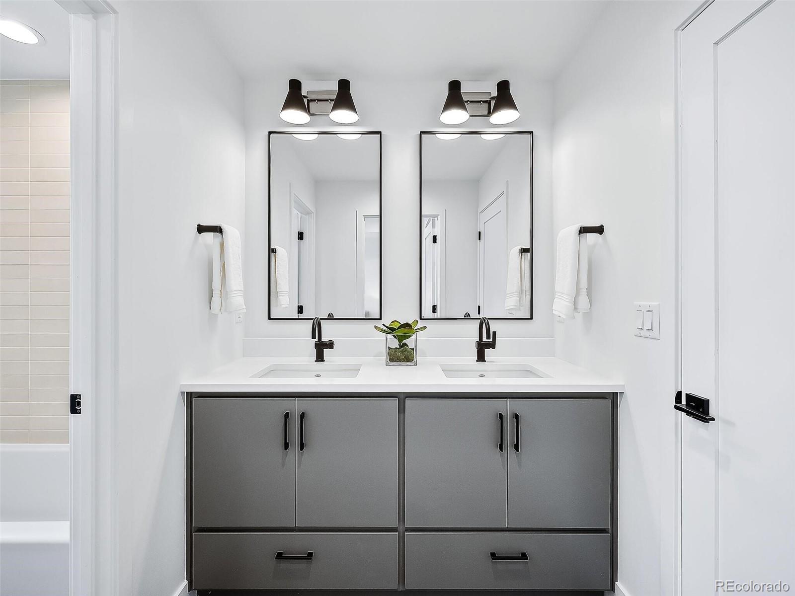 588 Adams Street Denver, CO 80206 - Photo 20 of 41 a bathroom with double vanity sinks and a mirror