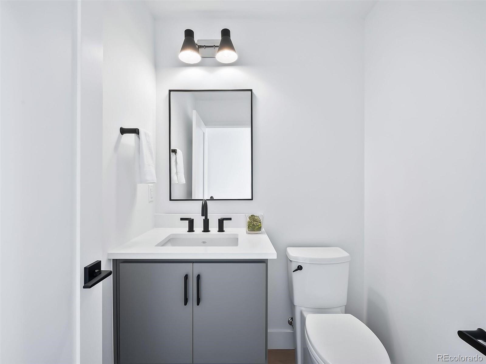 588 Adams Street Denver, CO 80206 - Photo 25 of 41 a bathroom with a toilet sink and mirror