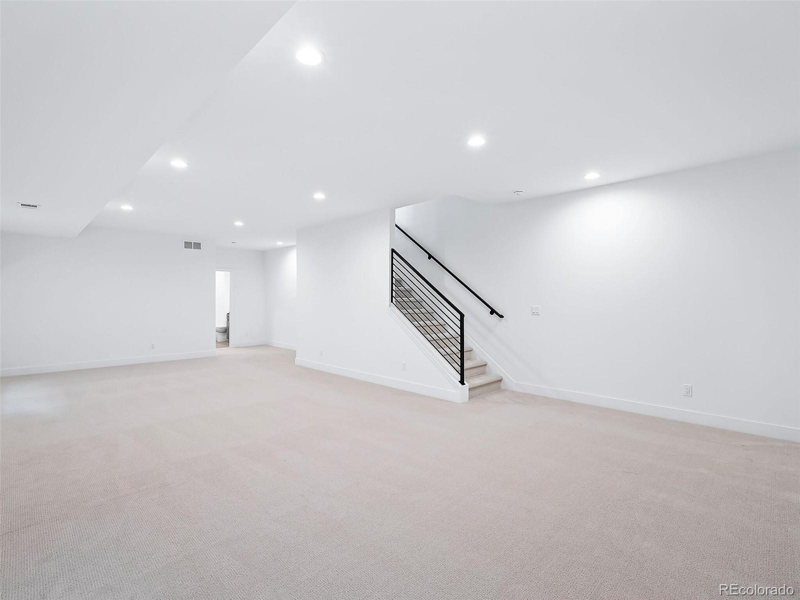 588 Adams Street Denver, CO 80206 - Photo 29 of 41 a view of an empty room with wooden floor and stairs