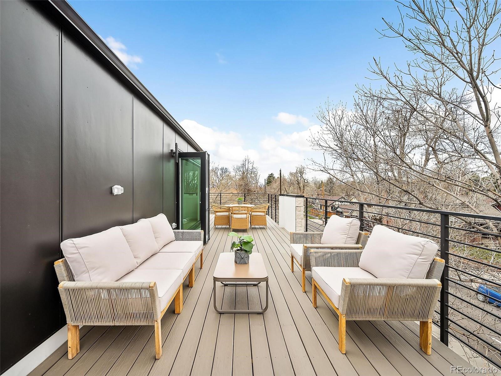 588 Adams Street Denver, CO 80206 - Photo 33 of 41 a balcony with wooden floor and outdoor seating