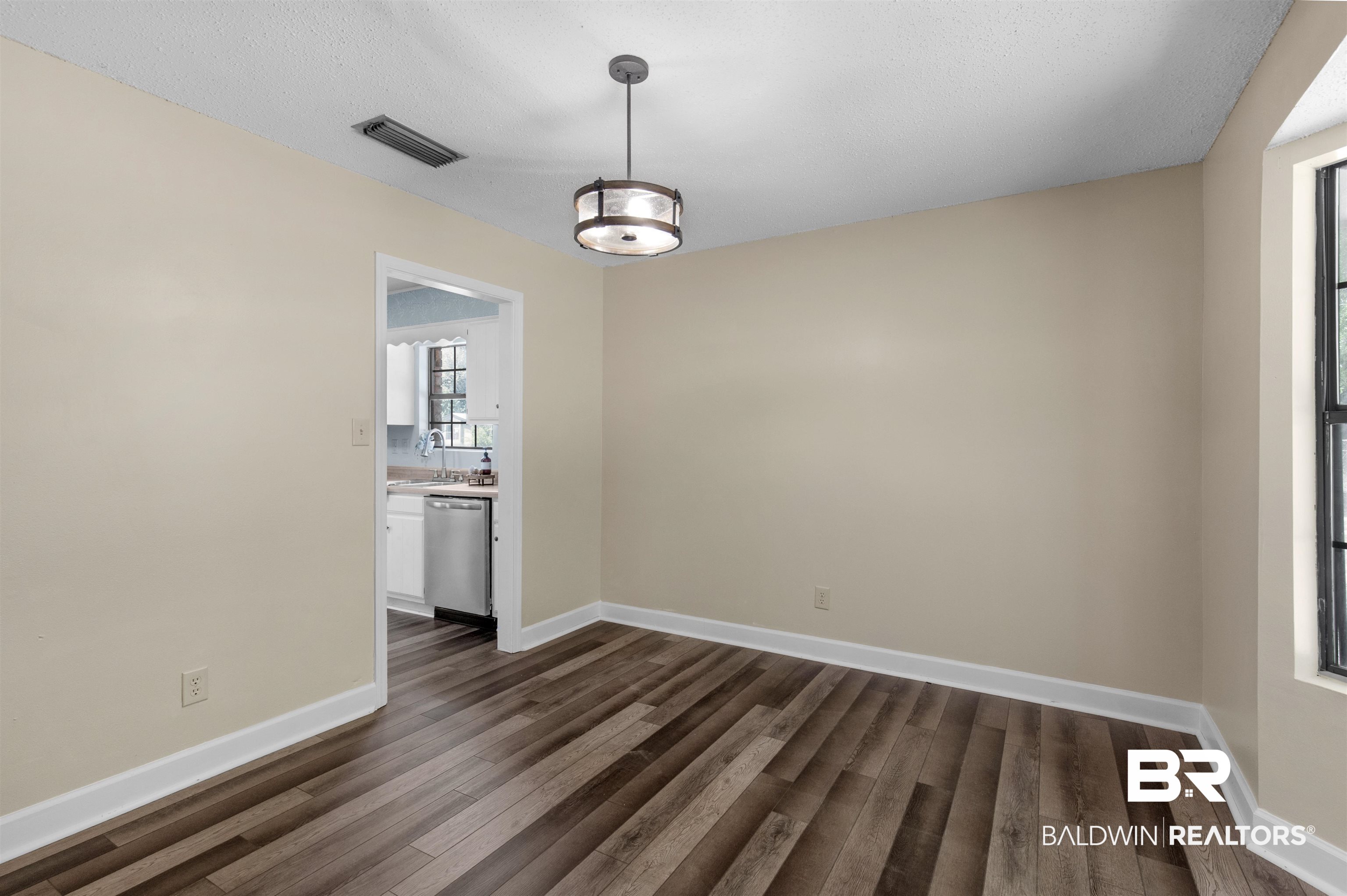 5665 Ulysses Road Eight Mile, AL 36613 - Photo 9 of 23 Unfurnished dining area featuring baseboards, visible vents, and dark wood-type flooring