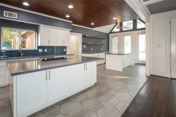 an empty room with wooden floor fireplace and windows