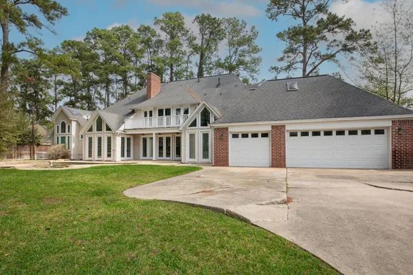 an empty room with wooden floor mirror and windows