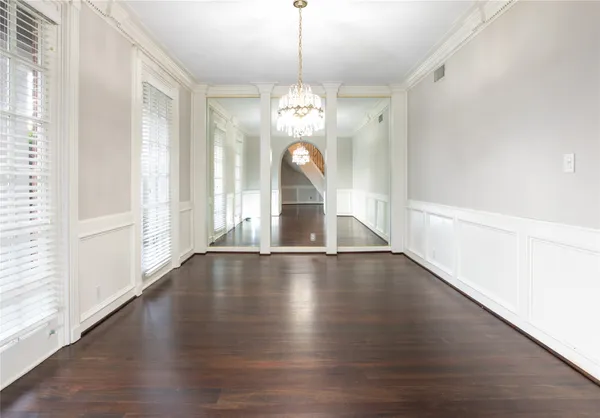 a view of a room with wooden floors and kitchen view