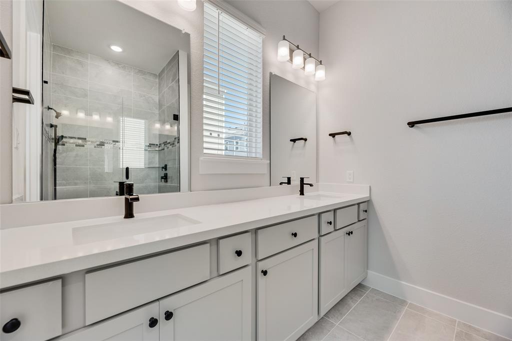 817 Ash Road Plano, TX 75075 - Photo 14 of 23 a bathroom with a shower sink and mirror