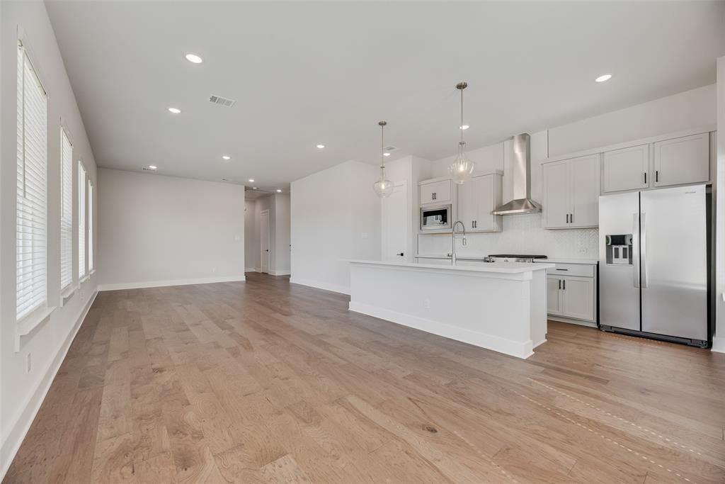 817 Ash Road Plano, TX 75075 - Photo 8 of 23 a large kitchen with kitchen island a sink a center island stainless steel appliances and a window