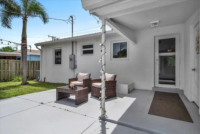a view of a patio with couches table and chairs and potted plants