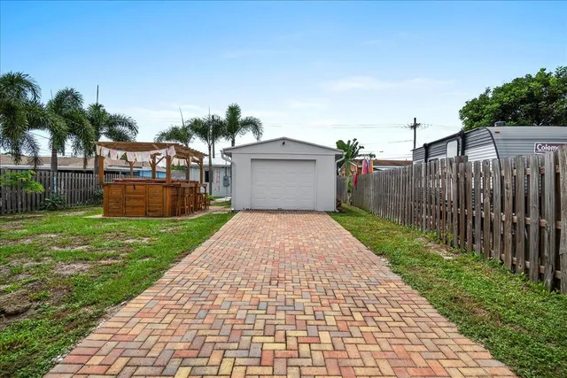 a front view of a house with a yard and potted plants