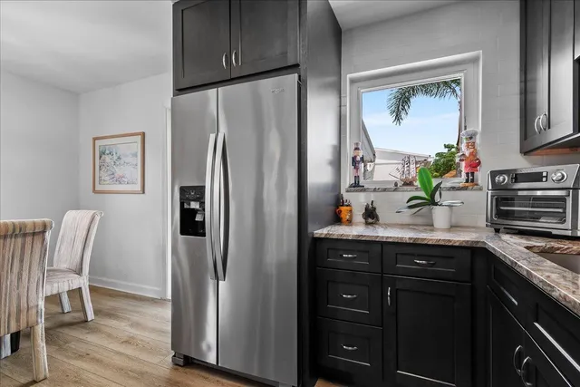 a kitchen with stainless steel appliances granite countertop a refrigerator and a sink