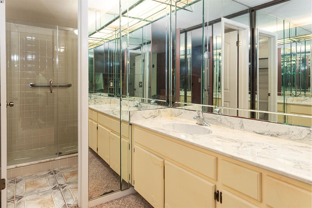 3 Escondido Circle, Unit 8 Altamonte Springs, FL 32701 - Photo 17 of 29 a bathroom with a granite countertop sink mirror and shower