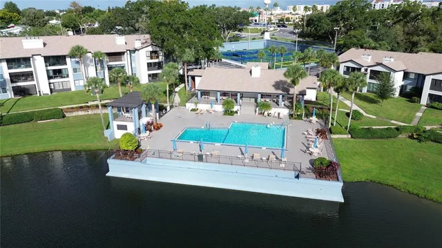 an aerial view of a house with a garden and lake view