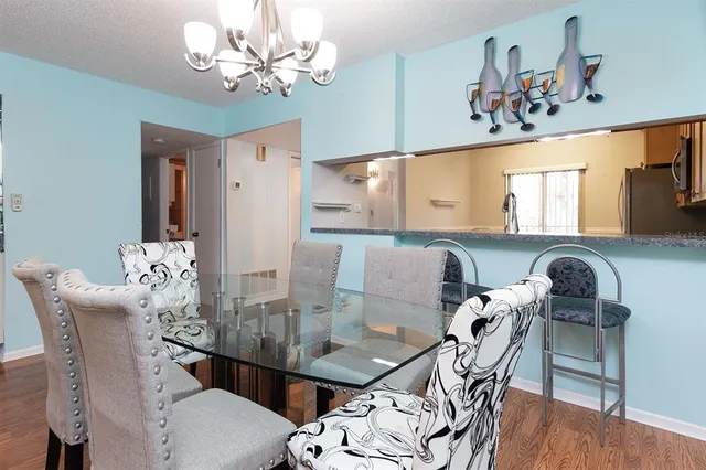 a view of a dining room with furniture a chandelier and wooden floor