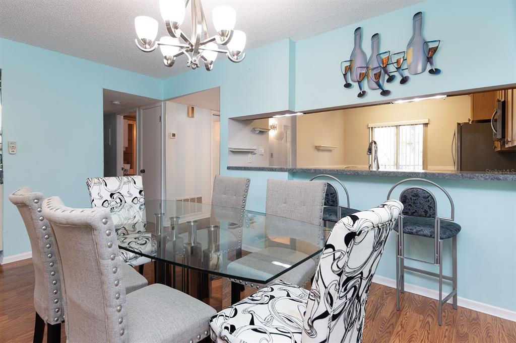 3 Escondido Circle, Unit 8 Altamonte Springs, FL 32701 - Photo 10 of 29 a view of a dining room with furniture a chandelier and wooden floor