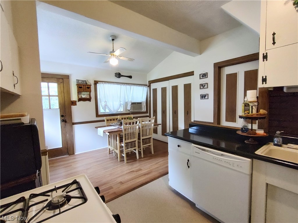 617 Mill Road Ravenna, OH 44266 - Photo 12 of 25 Kitchen with white cabinetry, dark countertops, white dishwasher, lofted ceiling with beams, and light hardwood floors