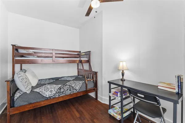 a bedroom with a bed and a wooden floor