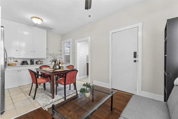 a kitchen with stainless steel appliances granite countertop a table chairs sink and cabinets